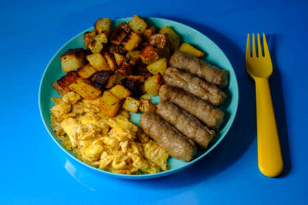 American breakfast food scrambled eggs with home fries and sausageの写真素材