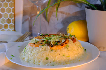 Fancy Italian shrimp risotto dinner served with a glass of fine pinot grigioの写真素材