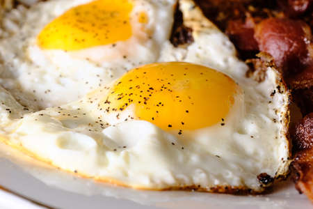 American breakfast two eggs sunny side up with bacon hash browns and a glass of fresh squeezed...