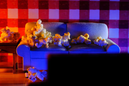 Movie and chill concept with popcorn on miniature couch watching the TVの写真素材