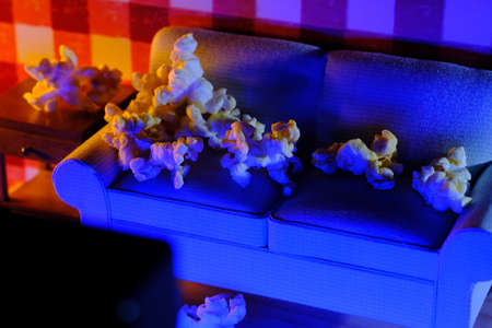 Movie and chill concept with popcorn on miniature couch watching the TVの写真素材
