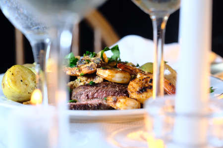 Gourmet surf and turf cajun shrimp and steak dinner entree with new potatoes at a fancy expensive weddingの写真素材