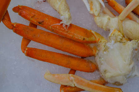 Large fresh seafood crab legs chilling on iceの写真素材