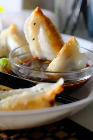 Homemade fried Asian potsticker dumpling appetizer with spicy ponzu dipping sauceの写真素材