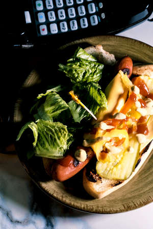 The works hot dog with retro landline corded phone in the backgroundの写真素材