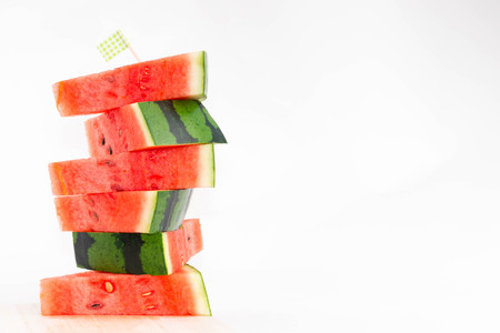 Stacked slices of fresh red watermelon isolated with cute flag.