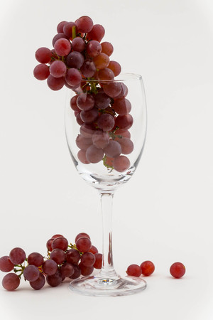 Fresh grapes in a wine glass on a wooden tableの写真素材
