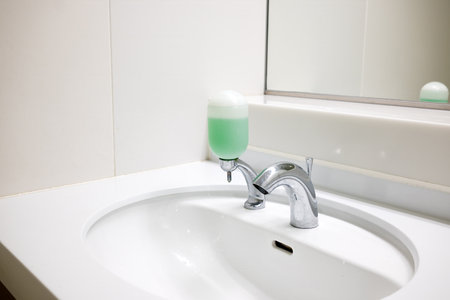 Public bathroom sink faucet with soap dispenser in Japanの写真素材