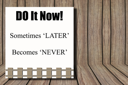 Brown wooden wall background and Do it now sometimes 'later' becomes 'never' wordの写真素材