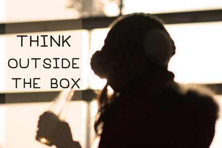 woman looking through the window with think outside the boxの写真素材