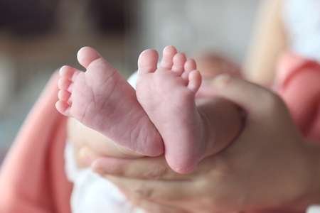 mama holding baby's hand and foot, play with baby.の写真素材