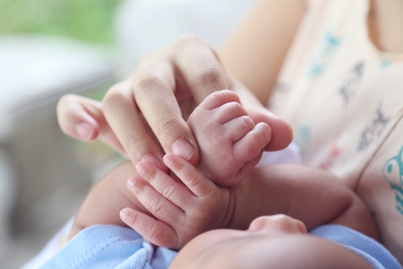 mama holding baby's hand, play with baby.の写真素材