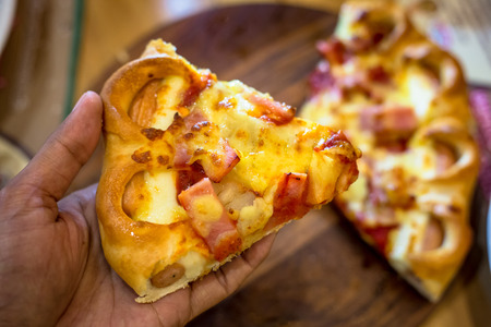 pizza on the wooden table with spices and garnishの写真素材