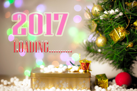 Merry Christmas and Happy New Year text with gift boxes and ornaments in white bokeh backgroundの写真素材