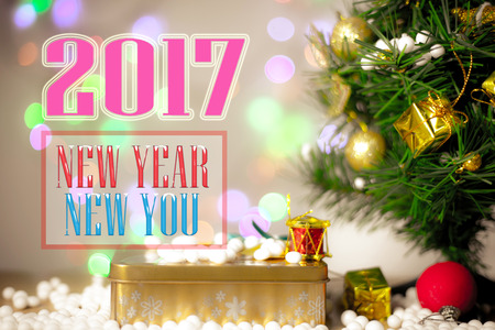 Merry Christmas and Happy New Year text with gift boxes and ornaments in white bokeh backgroundの写真素材