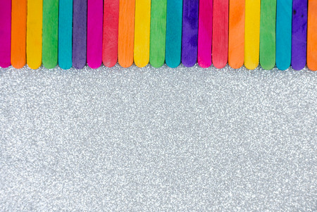 Colorful   sticks and white silver glitter texture background