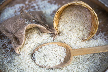 White uncooked rice on wooden surface.の写真素材