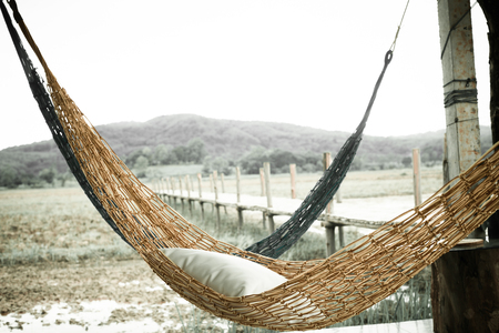Hammock on the rice field after harvested, mountain background, vintage style.の写真素材