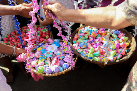 Thais bestowed ribbon-flowers on the poor/bystanders as a religious ritual of alms giving.の写真素材
