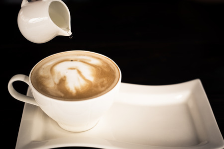 Beautiful late coffee on black wood background.の写真素材