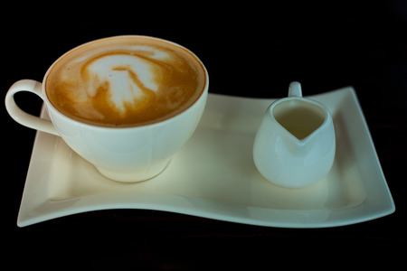 Beautiful late coffee on black wood background.の写真素材