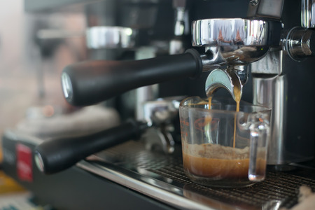 Close up barista hands making coffee by machine in coffee cafe.の写真素材