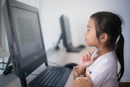 Thai cute girl looking for computer, Asian girl learning on her computer.のeditorial素材