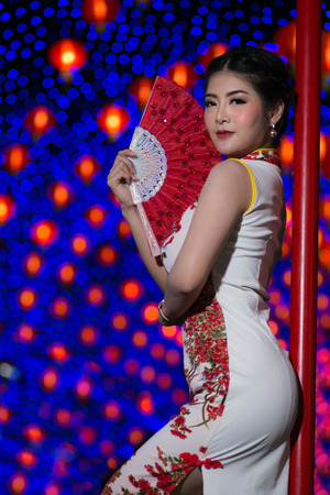 Portrait beautiful Asian woman in Cheongsam dress(Red and white Chinese dress), Happy Chinese new year concept with night light.の写真素材
