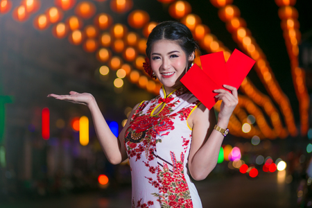 Portrait beautiful Asian woman in Cheongsam dress(Red and white Chinese dress), Happy Chinese new year concept with night light.の写真素材