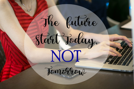 The future start today not tomorrow words on woman working on laptop.の写真素材