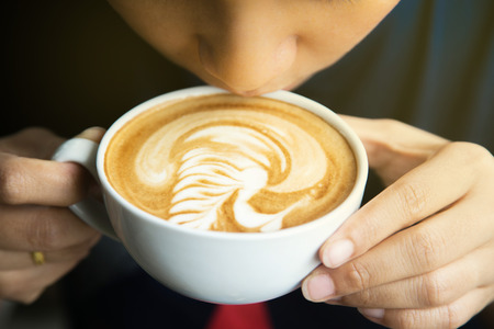 People drinking hot coffee, art latte coffee.の写真素材