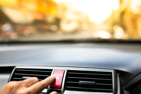 Finger pushes car emergency lights button.の写真素材