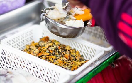 Mussels in white plastic box, Cooker prepare spicy seafood mix salad ingredients.