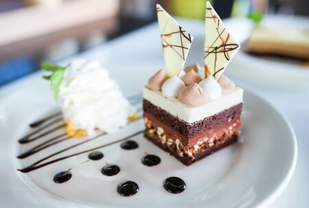 Delicious cake on white plate on table on light background.