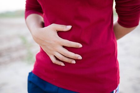 Woman touching her belly, healthcare concept. or Hemorrhoids, Health care concept.の写真素材