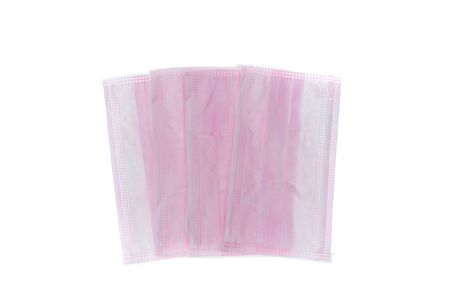 Medical mask of pink color for protection against flu or virus, epidemic and other diseases. Medical respiratory bandage face on white background.の写真素材