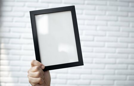 Blank Picture frame on white brick wall.の写真素材