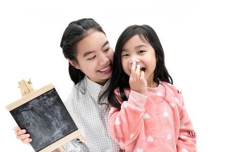 Sister and young sister holding chalkboard.の写真素材