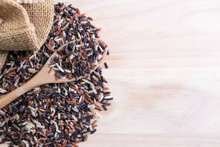 Food background. Mix healthy rice on a wooden spoon and sack.の写真素材