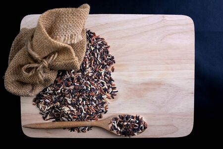 Food background. Mix healthy rice on a wooden spoon and sack.の写真素材