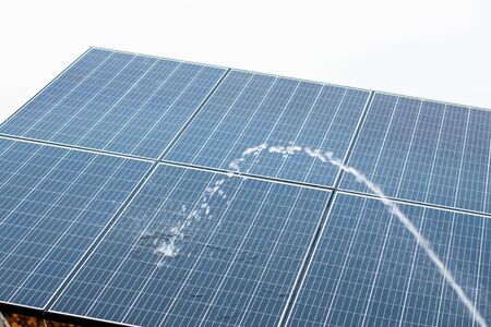 Washing and cleaning of Photovoltaic solar panels by water for dust removal and better absorption of sunlight as a source of energy.の写真素材