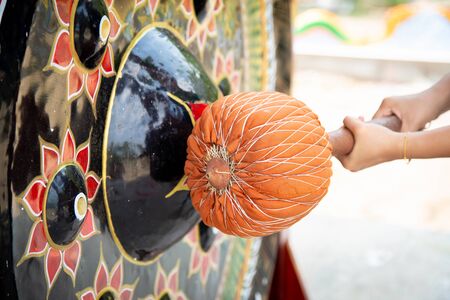 Buddhist strike a gong in Nongpai Temple, Nakhonsawan Province, Thailand.の写真素材