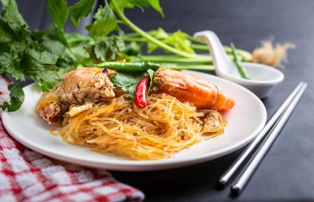 Casseroled prawns with vermicelli on white table or glass noodle bake with shrimp. Shrimp potted with vermicelli.の写真素材