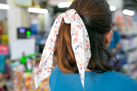 Portrait of a beautiful young woman with long hair with hair ribbon, back view.
