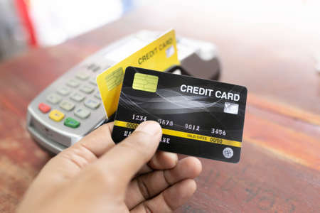 Hand using credit card with NFC technology in a supermarket close up.の写真素材