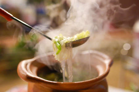 Close-up view of shabu shabu in hot pot. Fresh sliced meat, egg and vegetables, Thailand hotpot style.の写真素材