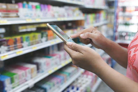 person use mobile phone in supermarket.の写真素材