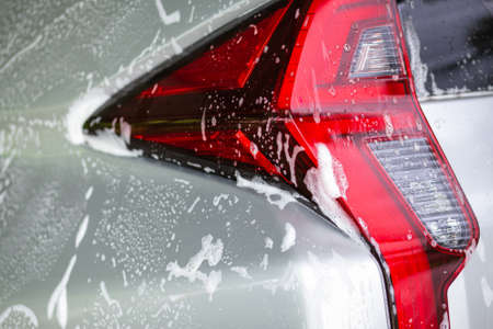 View of a tail light, the rear stop of the car is covered in soap foam.の写真素材