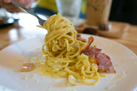 Spaghetti Carbonara with bacon and parmesan on wooden table. Italian food.