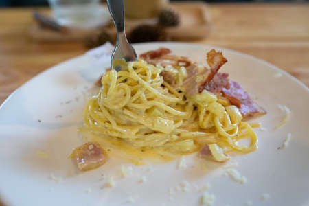 Spaghetti Carbonara with bacon and parmesan on wooden table. Italian food.の写真素材